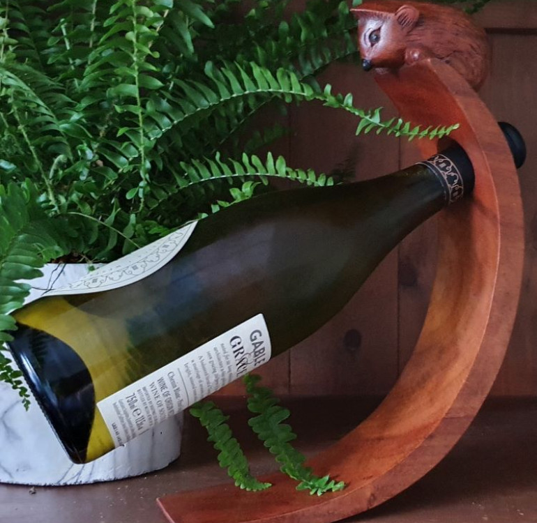 hand carved curved wine bottle stand with a hedgehog design