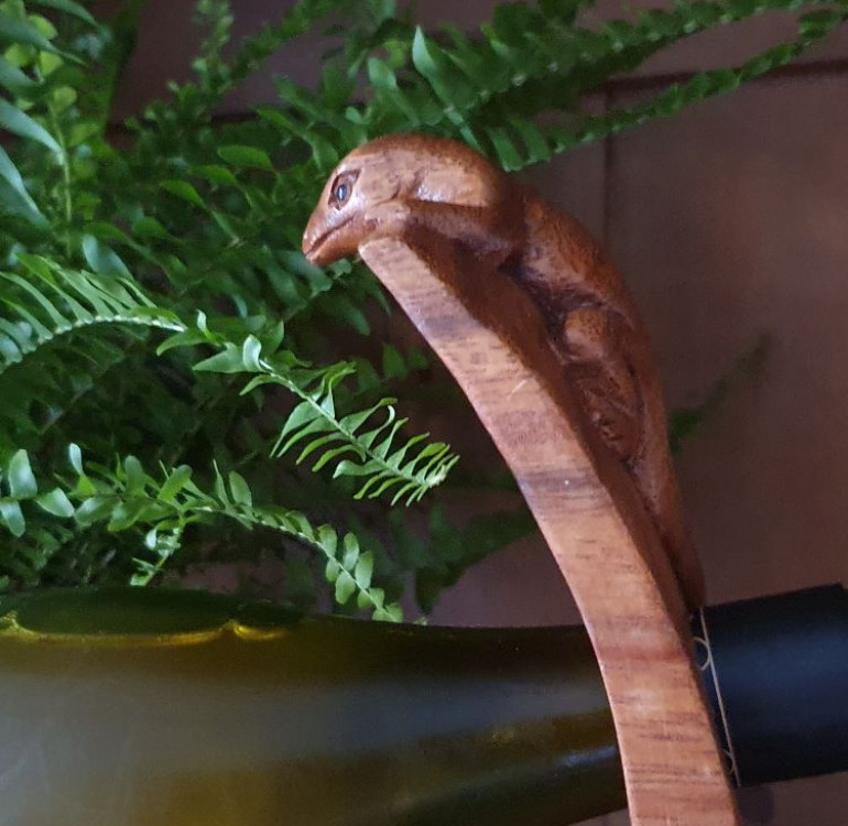 hand carved curved balancing wine bottle holder with a lizard design