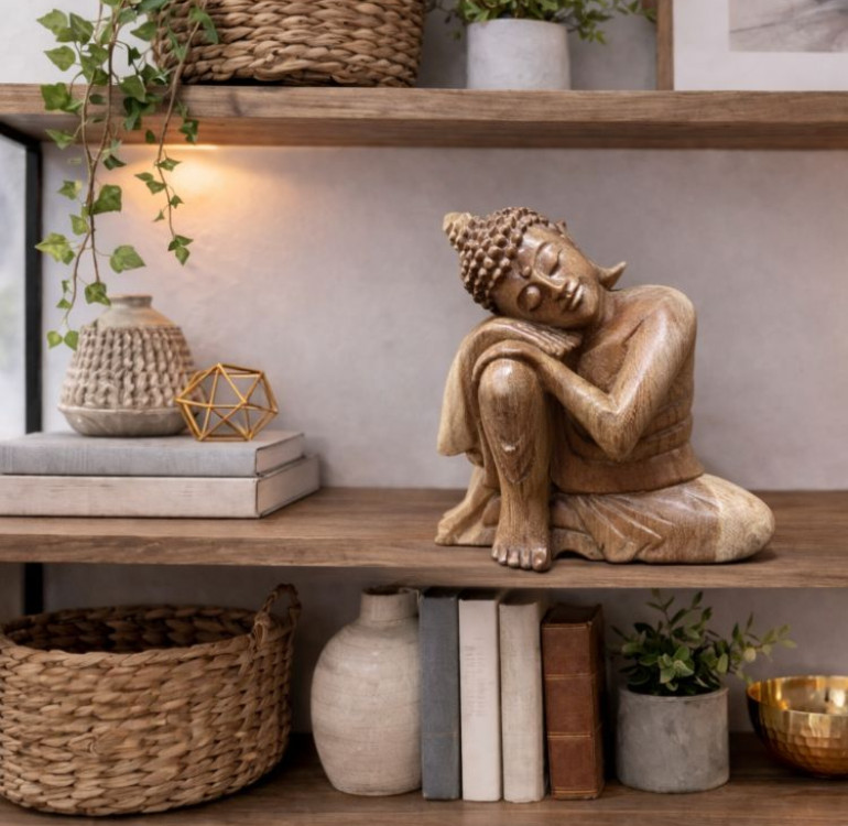 Wooden carved dreaming buddha, a Buddha sitting and resting again a bent up knee, a calming statue
