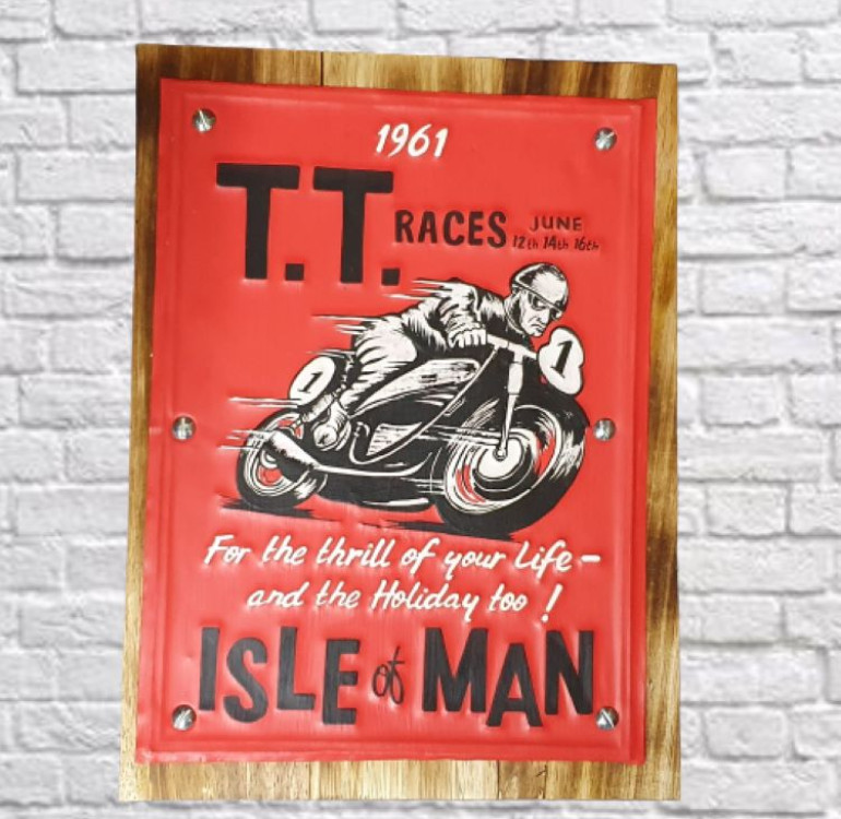 A wooden and tin red sign decorated with TT Isle of Man