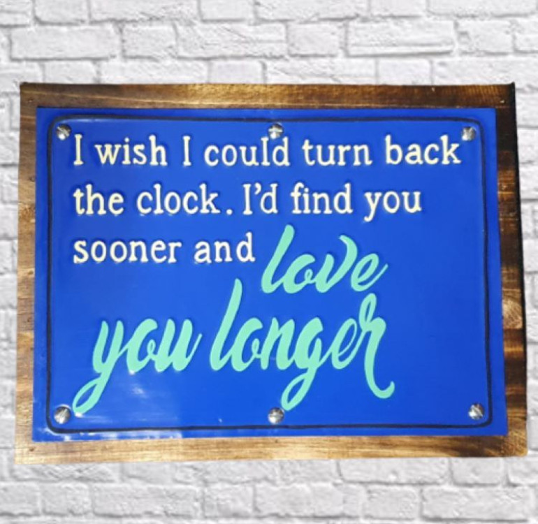 a wooden backboard with a painted tin front saying I wish I could turn back the clock. I'd find you sooner and love you longer