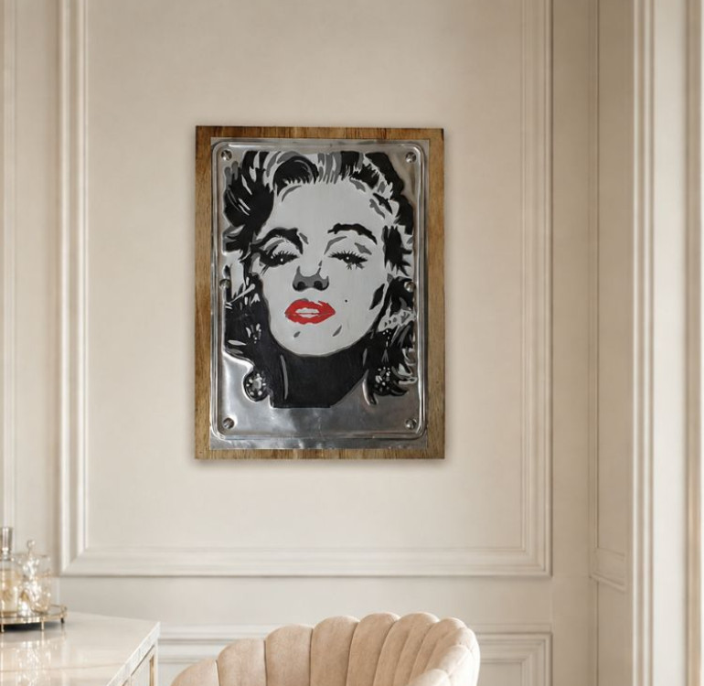 A wooden backboard with a tin embossed and painted front picture of Marilyn Monroe