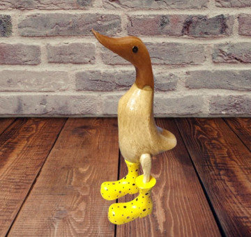 a hand carved bamboo wooden duck with yellow boots