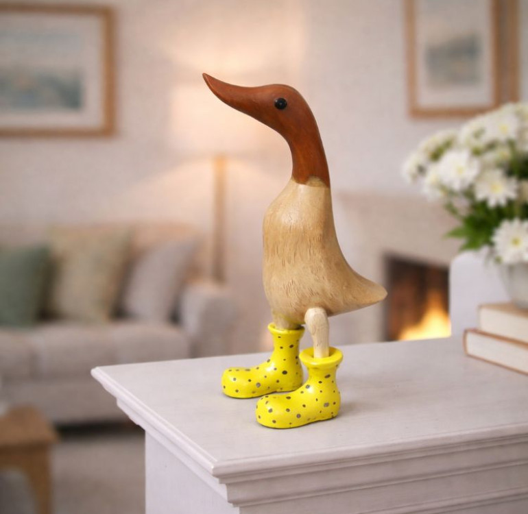 a hand carved bamboo wooden duck with yellow boots