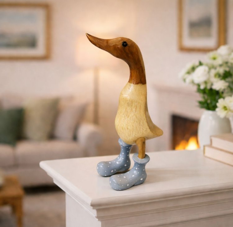 a small wooden hand carved bamboo duck with a grey boot