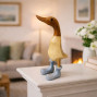 a small wooden hand carved bamboo duck with a grey boot