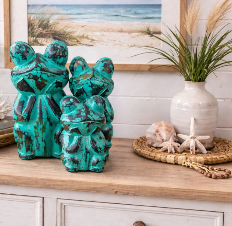 a family of hand carved green frogs
