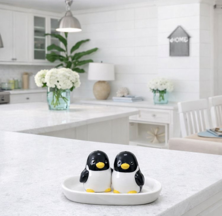 a set of baby penguin novelty salt and pepper ceramic shakers on a base