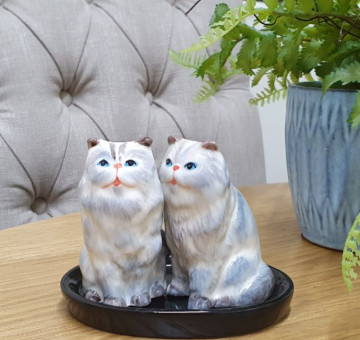 A set of grey fluffy cat salt and pepper shakers made from ceramic on a base