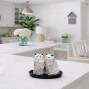 A set of grey fluffy cat salt and pepper shakers made from ceramic on a base