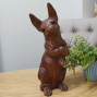 a wooden hand carved Chihuahua standing tall, real character