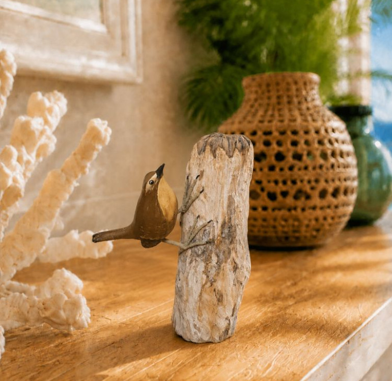 a beautiful hand carved and hand painted wren perching on a piece of natural wood