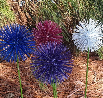 an image of all 4 colours of handcrafted metal alliums for outdoor use that we offer, white, blue, pink and purple