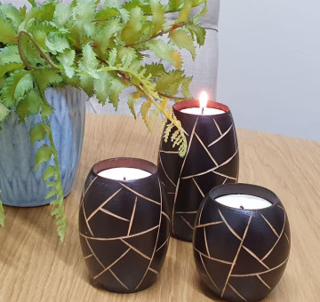 an example of a set of 3 barrel shape wooden candle holders hand carved with an abstract design, designs differ from set to set