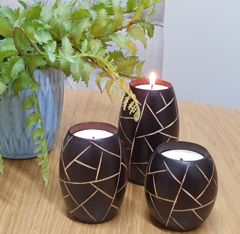 an example of a set of 3 barrel shape wooden candle holders hand carved with an abstract design, designs differ from set to set