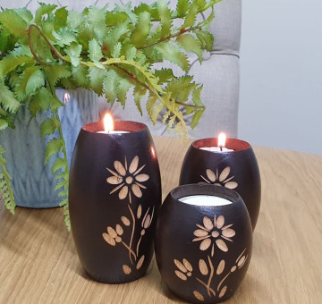 an example of a set of 3 hand carved barrel shape candle holders with a flower design, please note flower designs differ from set to set