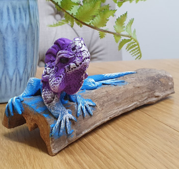 a handmade blue and purple clay wood lizard