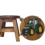 a handmade wooden childrens stool with a hand painted green tractor on the seat with yellow wheels