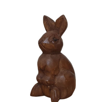 a hand carved rabbit sitting surveying everything around him ornament