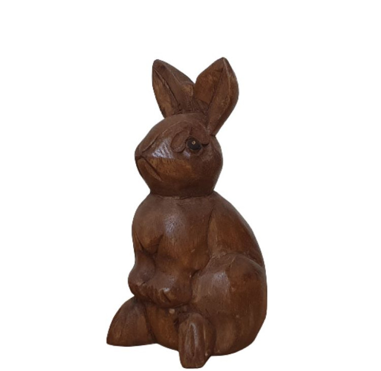 a hand carved rabbit sitting surveying everything around him ornament