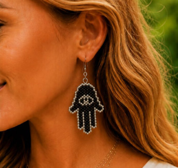 a handmade set of earrings, hand shaped with henna effect on them, black and white