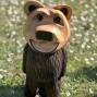 a hand carved outdoor wooden bear sculpture, smiling happy bear