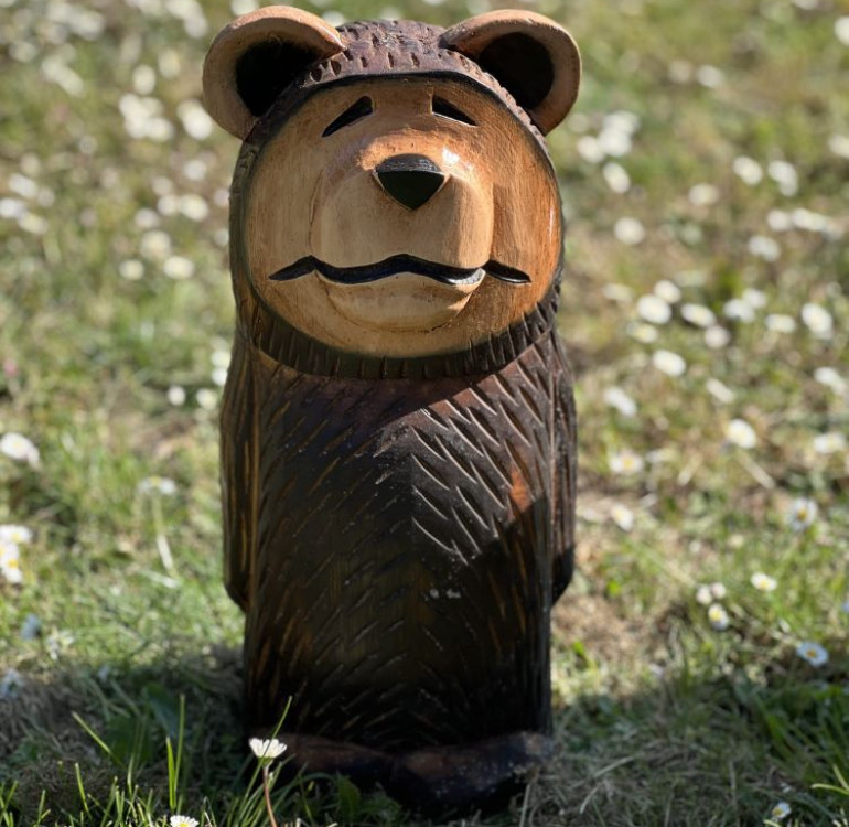 a hand carved outdoor wooden bear sculpture, smiling happy bear