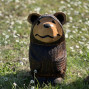 a hand carved outdoor wooden bear sculpture, tired squinty eyes