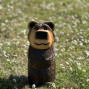 a hand carved outdoor wooden bear sculpture, tired squinty eyes