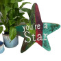 hand painted wooden sign in greens and reds. You're a star painted in white on the front.