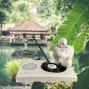a white stone effect buddha on garden with incense sticks and candle