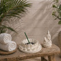 a white stone effect buddha on garden with incense sticks