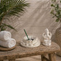 a white stone effect buddha on garden with incense sticks and candle