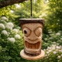 a hand carved bird nesting box in the shape of a tiki face