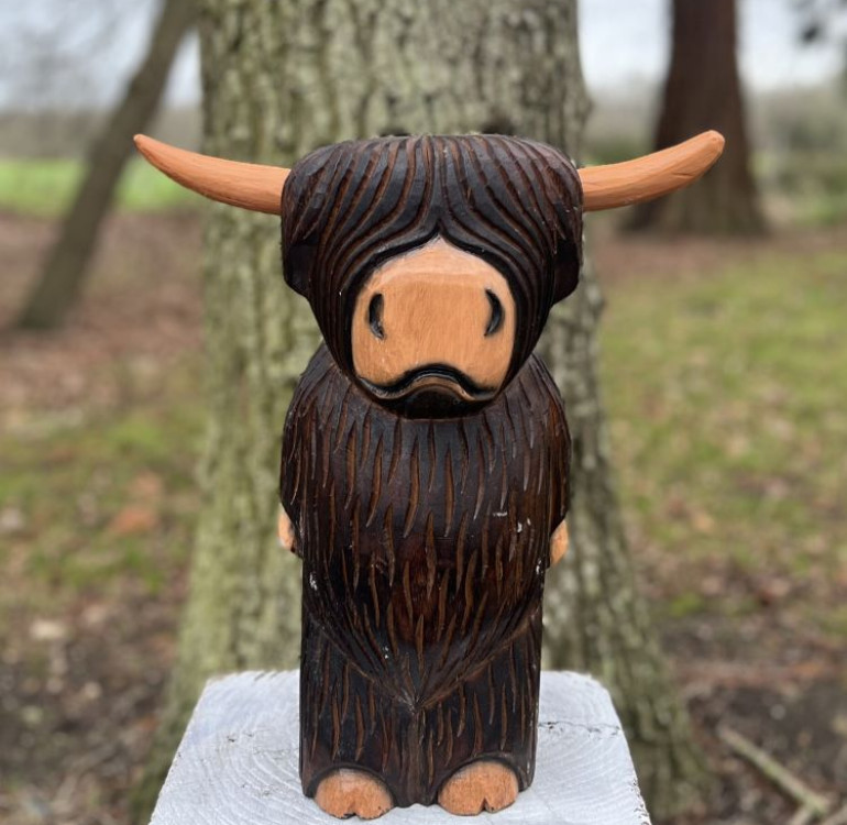 a hand carved outdoor wooden bear sculpture, smiling happy bear