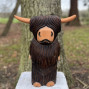 a hand carved outdoor wooden bear sculpture, smiling happy bear