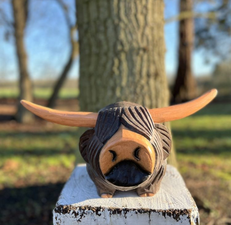 a hand carved outdoor wooden bear sculpture, smiling happy bear