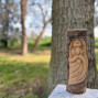 a hand carved wall hanging of a Green Man 30cm in length and made on a half log