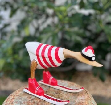 handmade bamboo duck dressed in a handpainted red and white striped outfit skiing