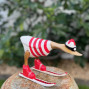handmade bamboo duck dressed in a handpainted red and white striped outfit skiing